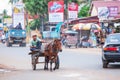 Cambodian man riding a local horse carriage on the road to Phnom Phenh. Royalty Free Stock Photo